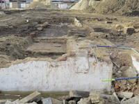 907177 Gezicht op de fundamenten van oude gebouwen, blootgelegd tijdens archeologisch onderzoek op het terrein voor het ...